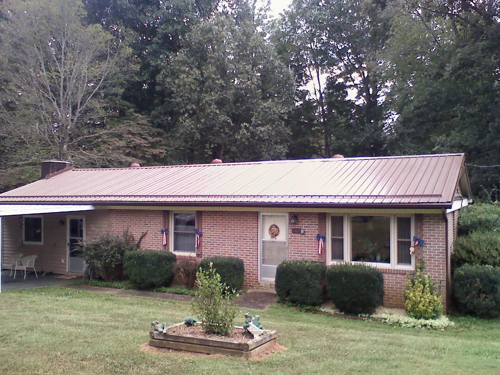 Bronze metal roof on a brick ranch home with a carport in Rossburg
