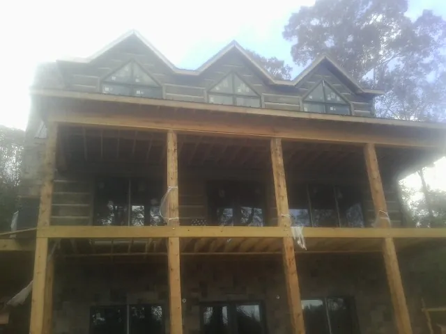 Dormers and porch framing on a large log home under construction — Roof Coating work by our crew in Rossburg