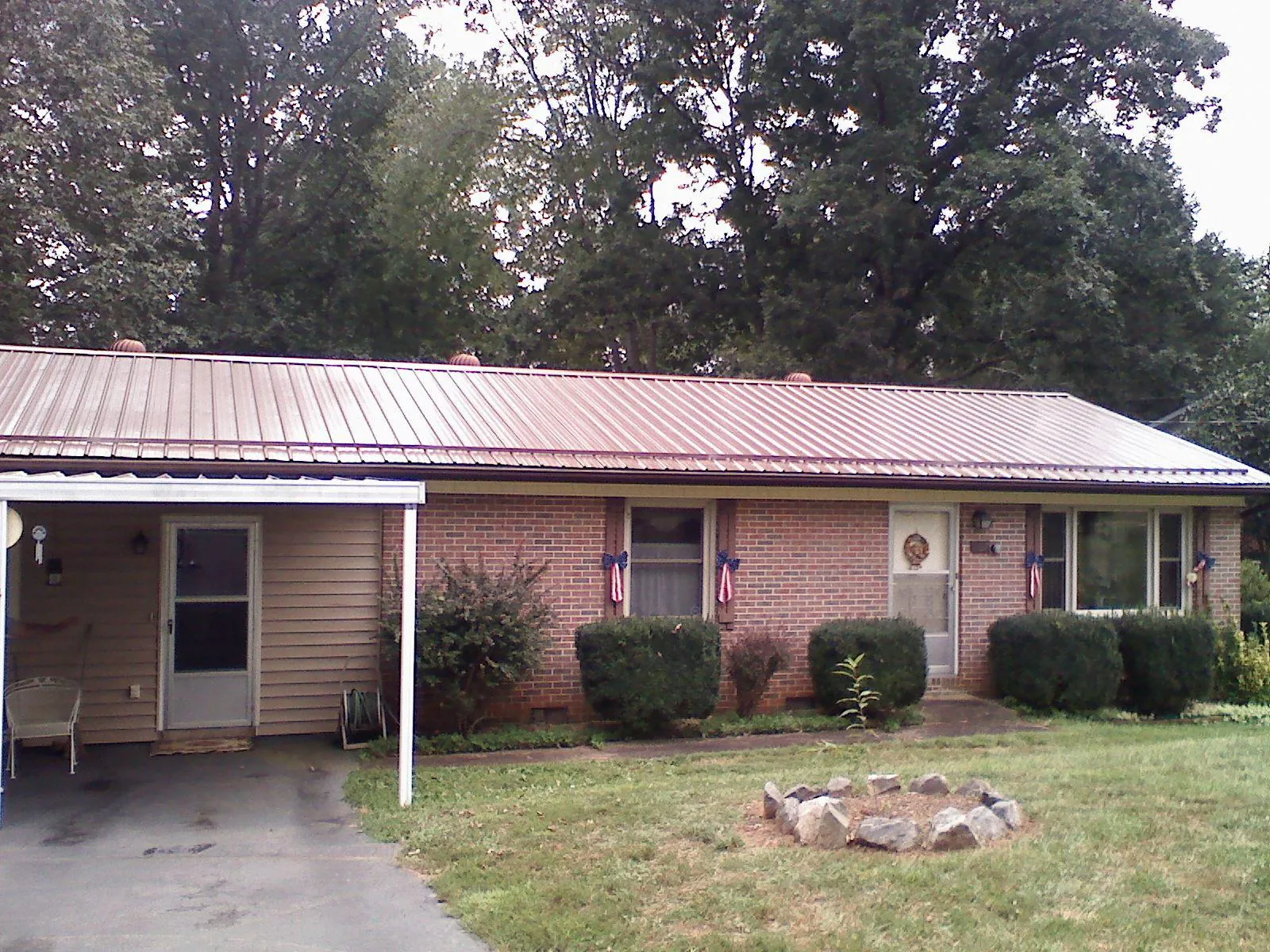 Bronze metal roof and carport on a brick ranch home — Roof Repair work by our crew in Rossburg